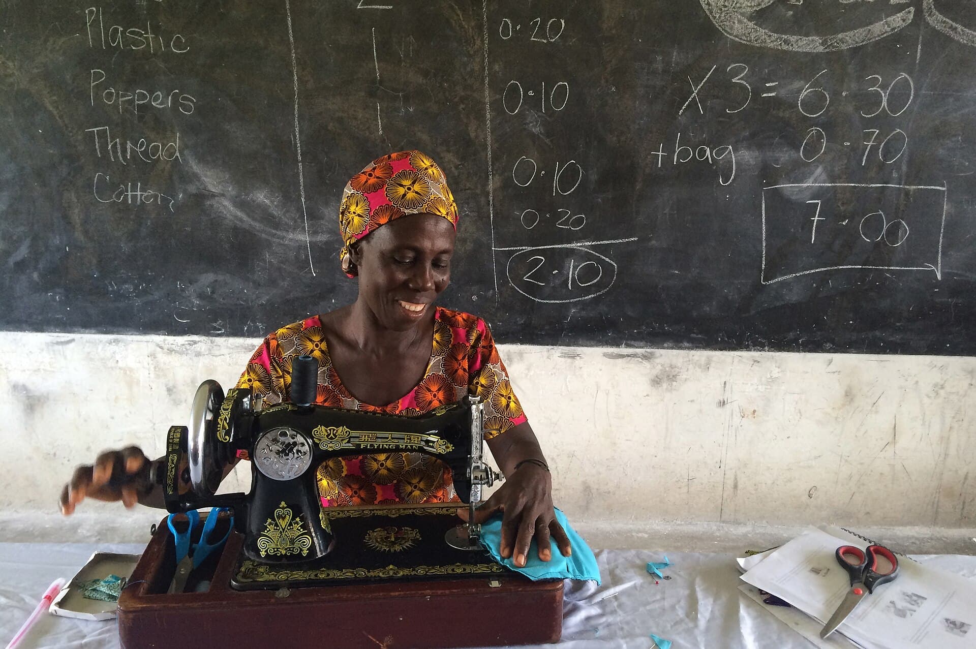 A woman sewing reusable sanitary pads at a community workshop