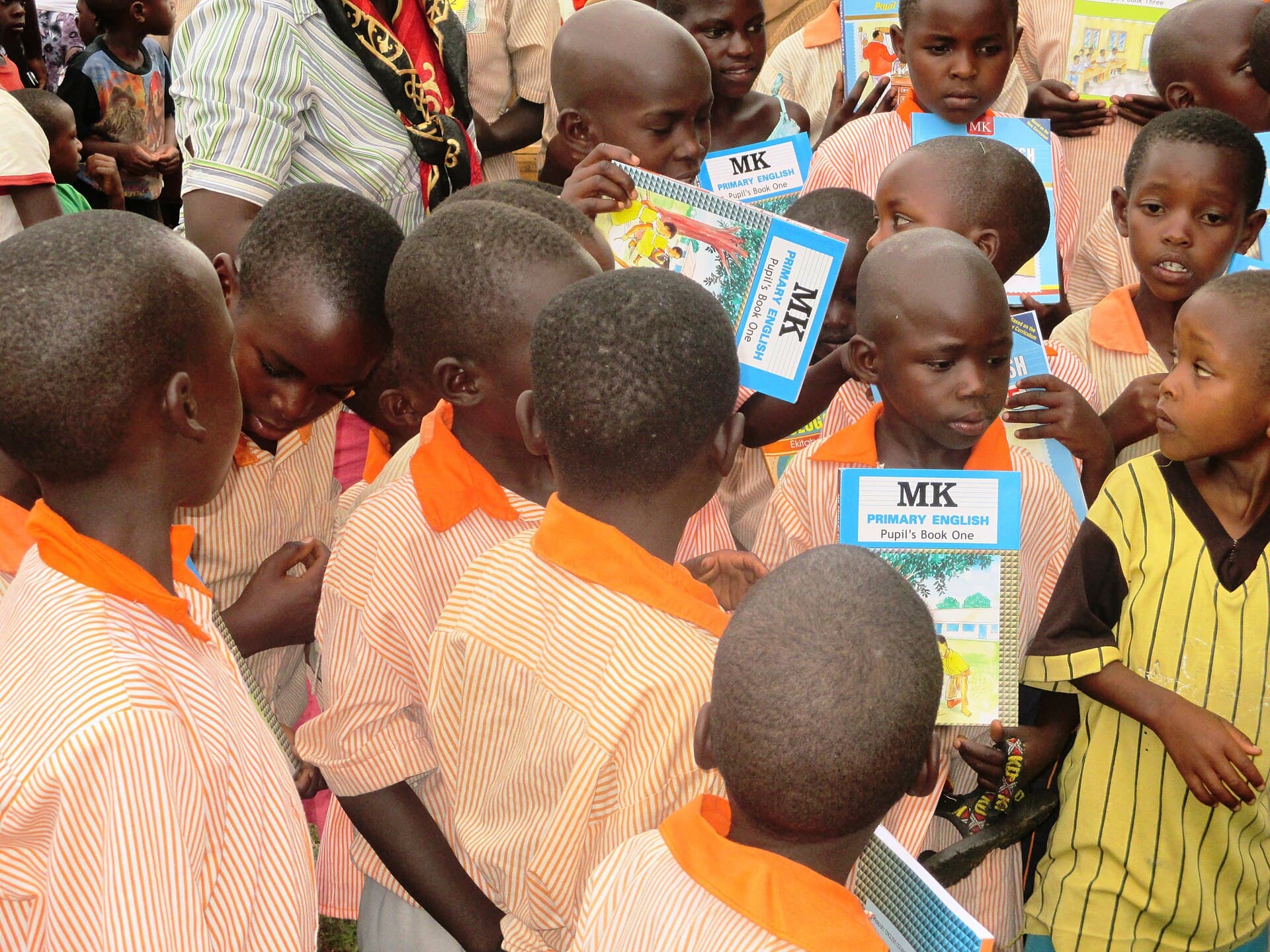 Pupils at Green Valley Kasanje Primary School, Uganda, looking at new English textbooks